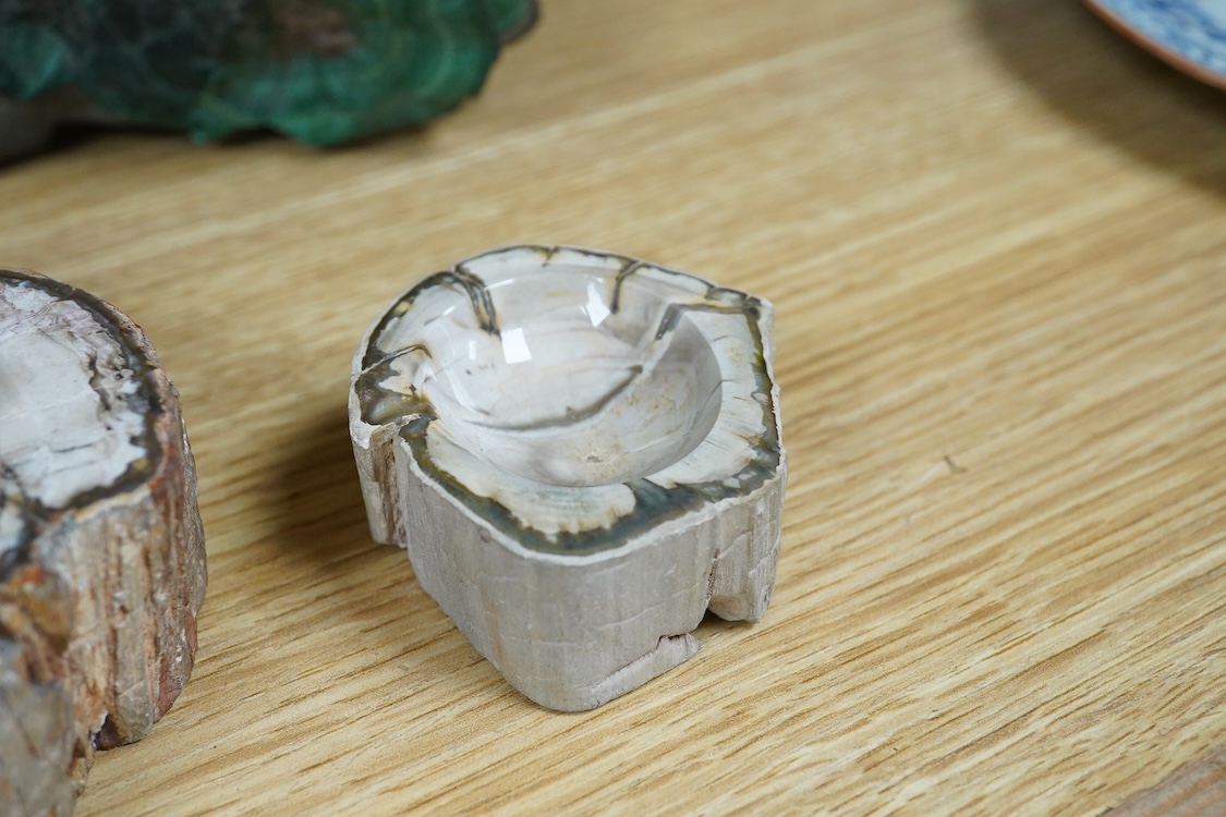 Two petrified wood ashtrays, a malachite rock, three onyx bowls, one with cover, and one other item, larger ashtray 17.5cm wide